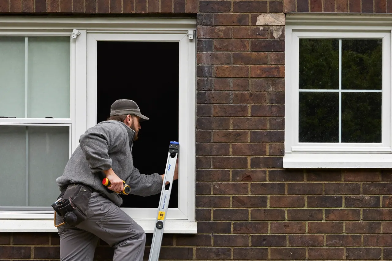 An installer fitting a new window into a UK home