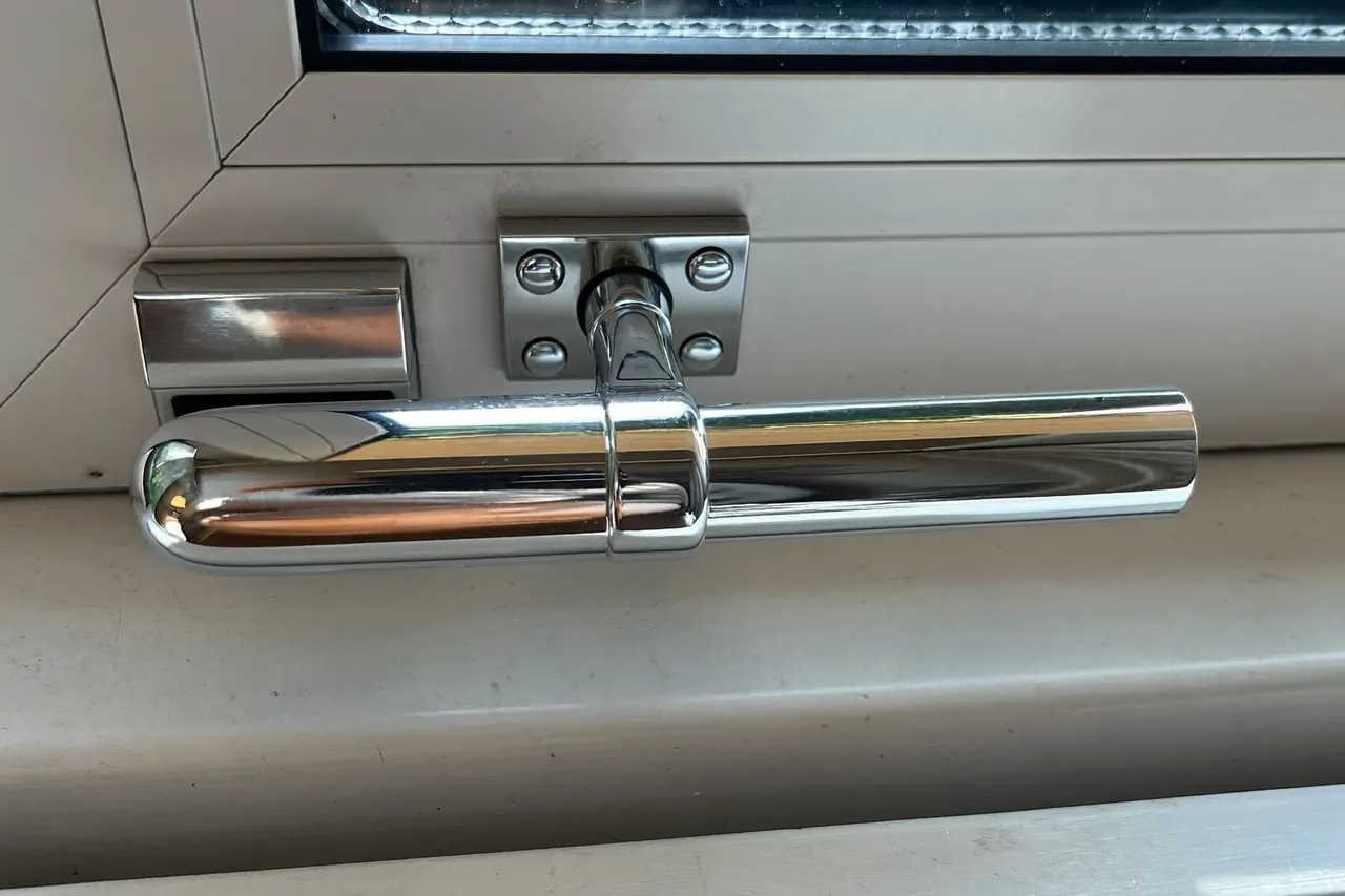 Close-up of a window handle and locking hardware